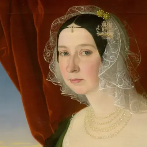 Painting of a woman in green writing a letter with a quill